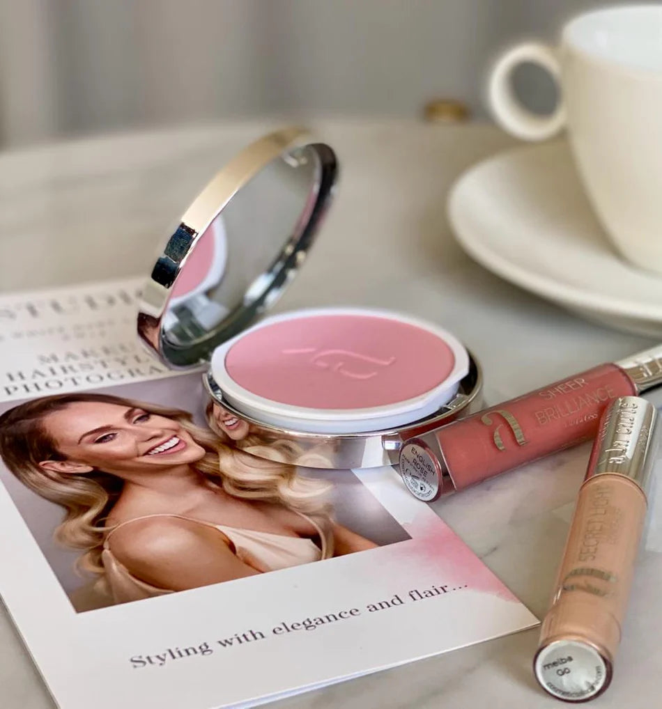 Compact mirror and lip gloss on a Kristina Gasperas brochure
