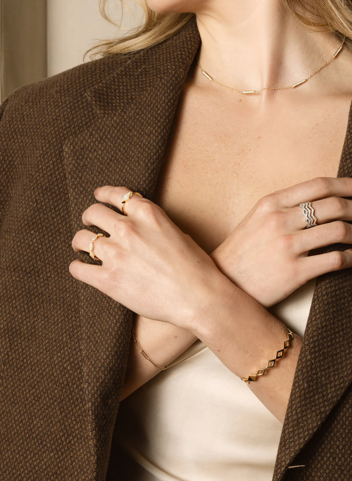 Woman in a brown blazer wearing Carin Susann gold jewellery