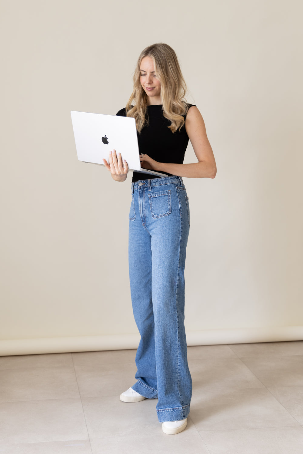 Julia Dennis standing with an open laptop